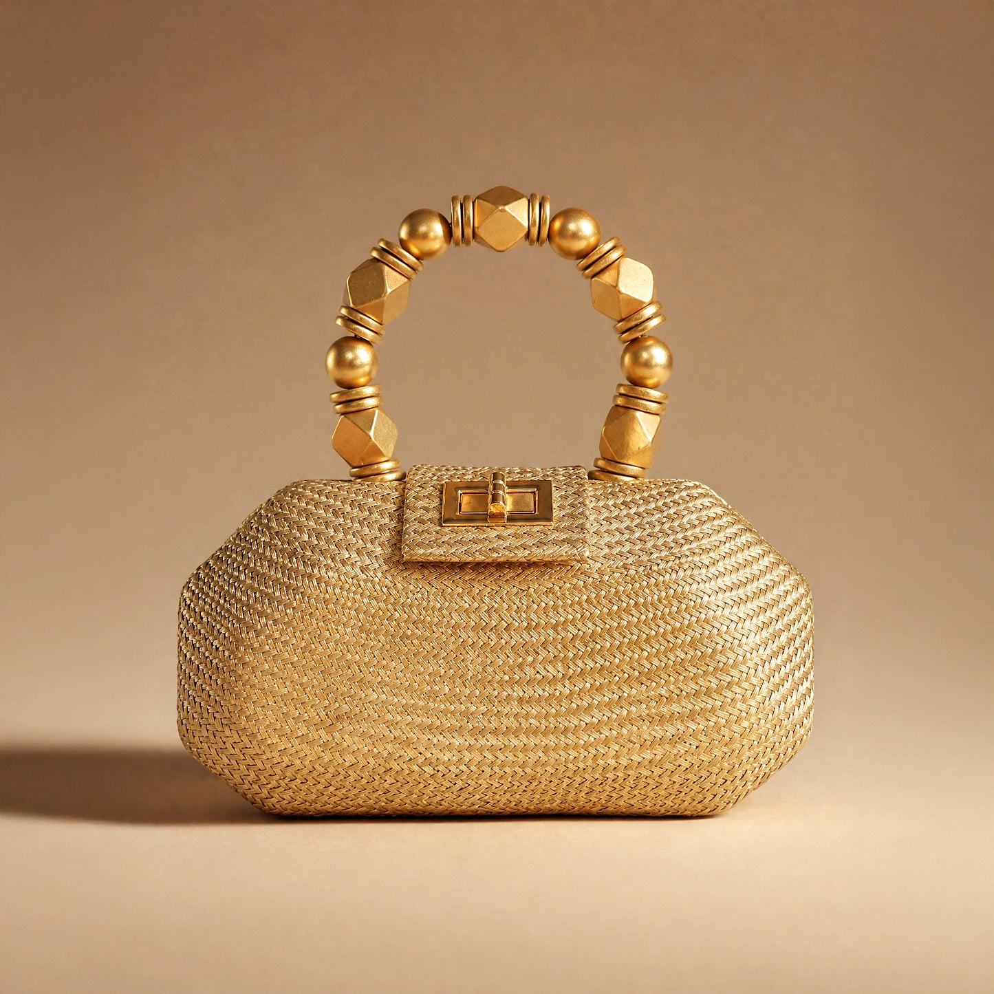 The Melia gold woven straw occasion bag styled against a warm gold backdrop