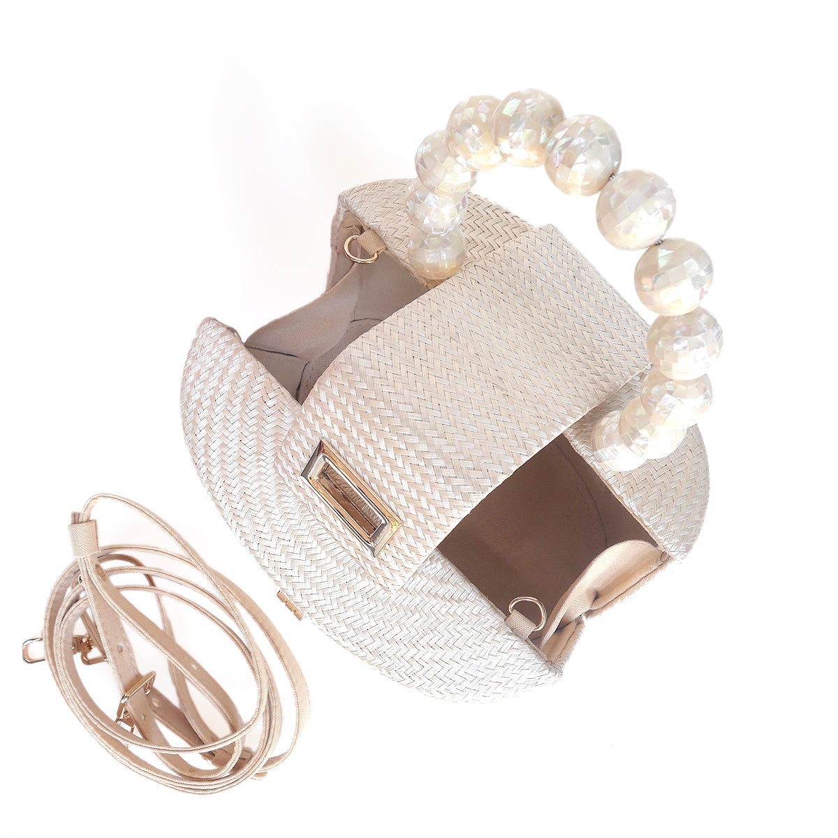 A cream-colored woven straw handbag with a unique top handle made of large, faceted pearl-like beads, shown alongside a matching rolled-up beige shoulder strap on a white background.